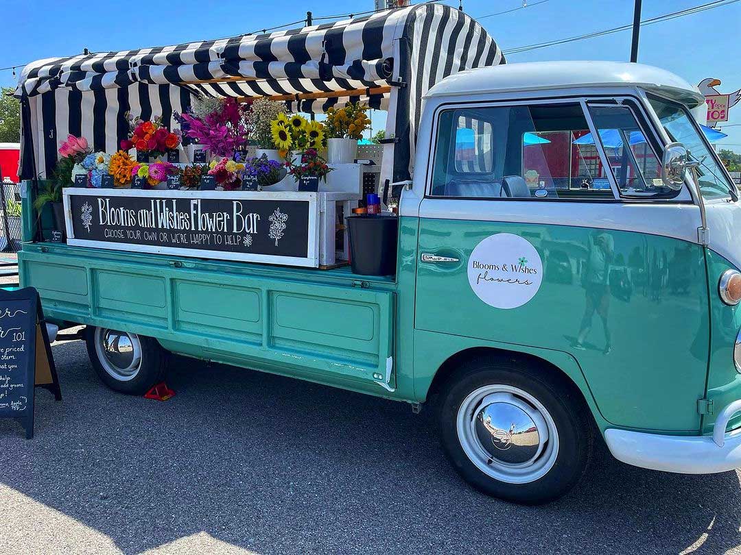 The blooms and wishes truck on a sunny day with flower arrangement for sale